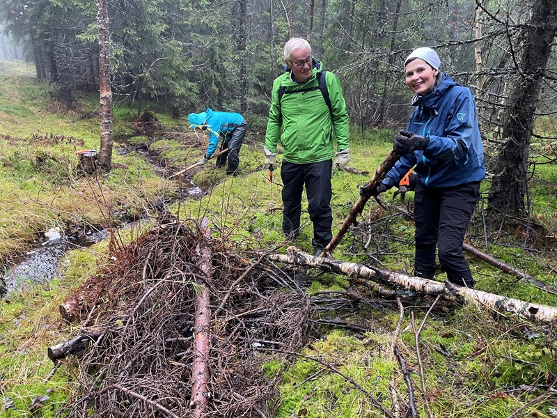 Nina Rodem, Thomas Knutzen og Jeanette Holter drenerer bekk i Bislingløypa. Sokkene brukte vi også. Foto: Lene Li Dragland